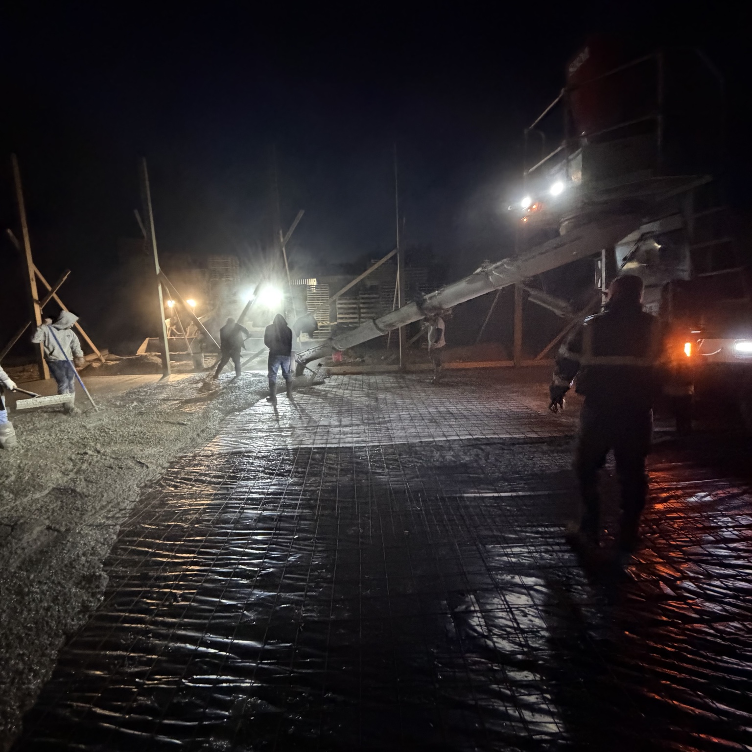 Crew placing and finishing concrete at night