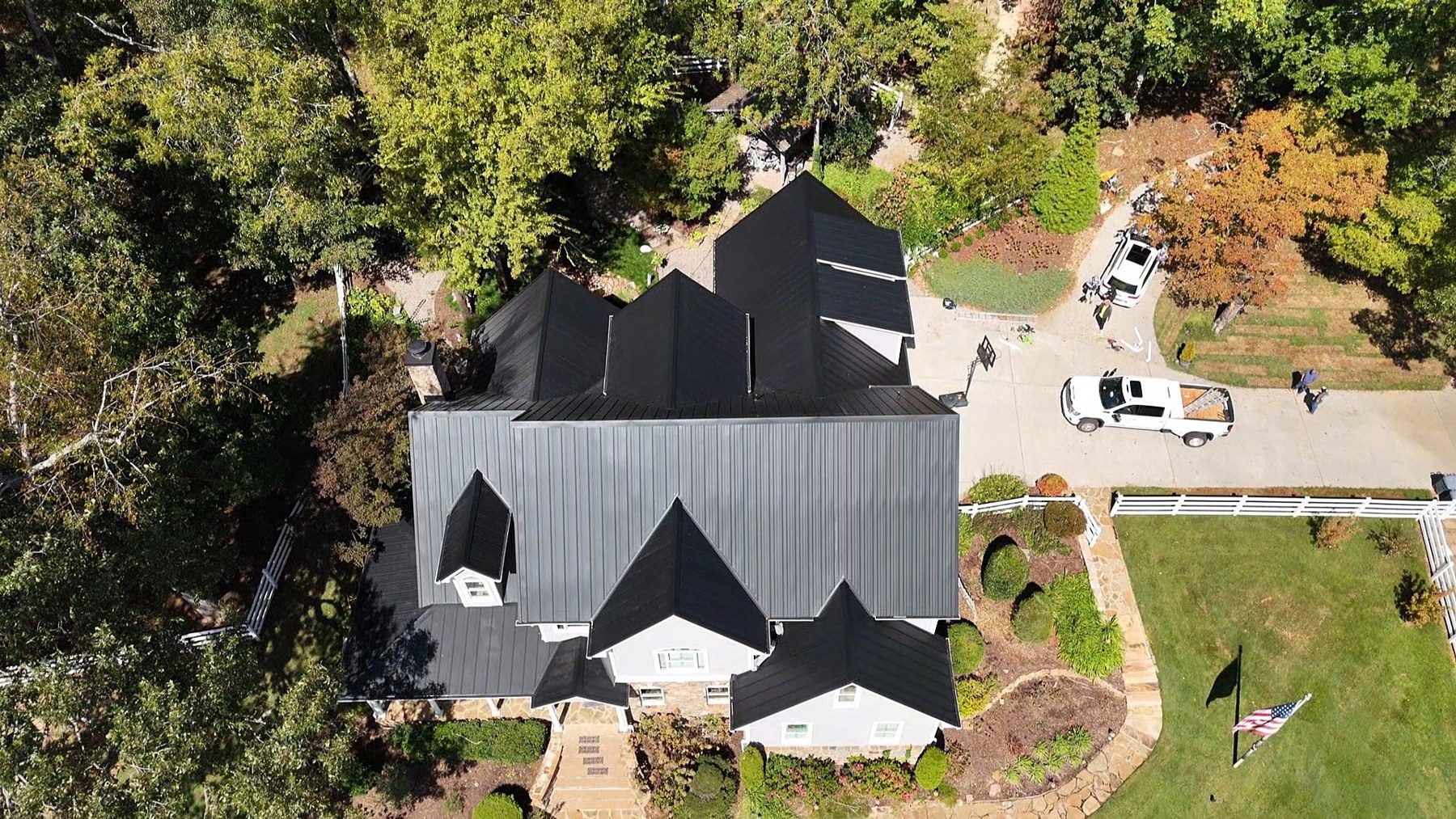 Aerial view of a completed standing seam metal roof surrounded by trees
