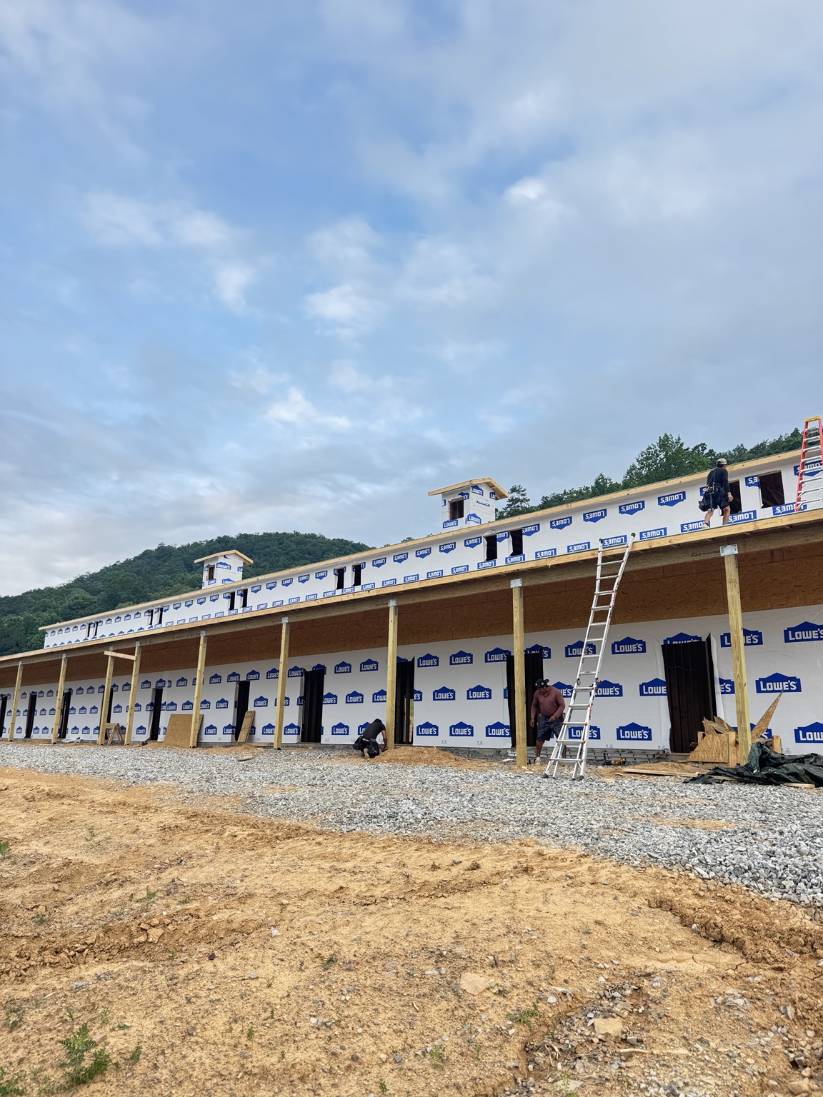 Exterior building work with house wrap and ladders