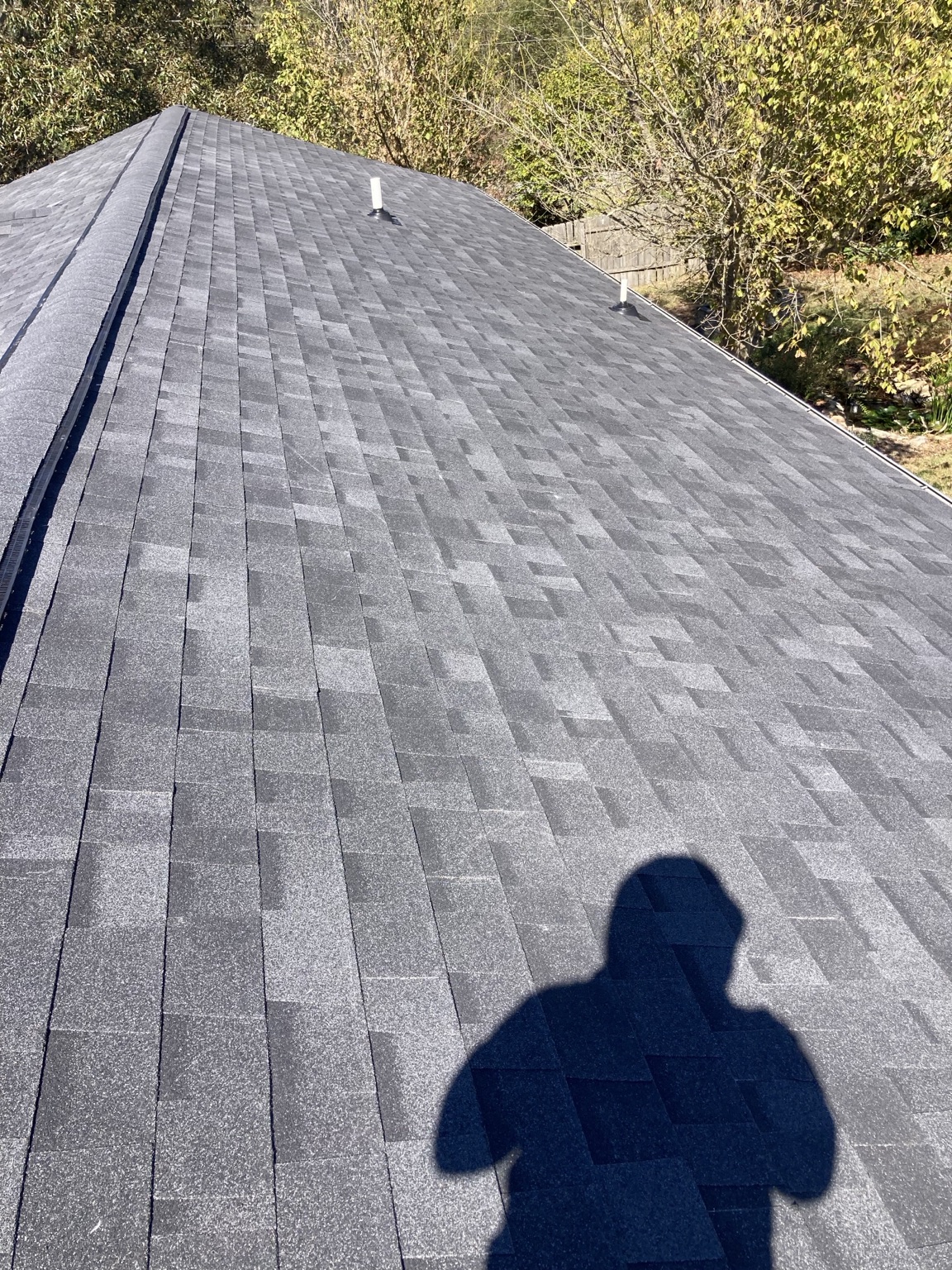 Completed asphalt shingles along roof planes and ridge